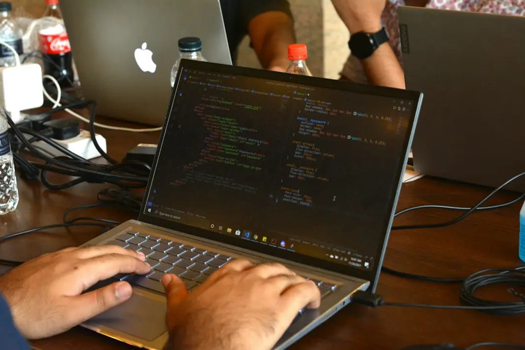 Equipo de desarrolladores revisando código limpio en pantalla, colaborando para evitar dependencia de un programador