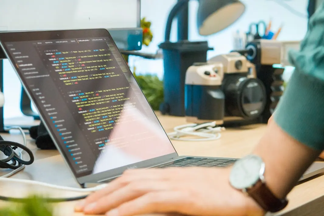 Equipo de desarrollo de software chileno trabajando en oficina moderna con computadores y gráficos de datos, simbolizando outsourcing TI en Chile y transformación digital para pymes.